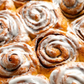 Close-up of glazed cinnamon scroll swirls with icing, Cinnamon Scrolls scented candle inspiration – Harvey & Co. Sydney®