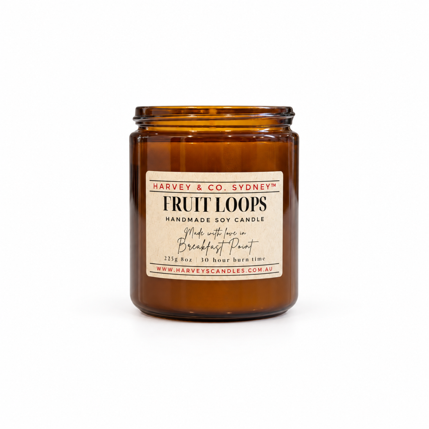 An amber glass jar candle with a cream-colored label reading 'Harvey & Co. Sydney Fruit Loops Handmade Soy Candle' on a clean white background.