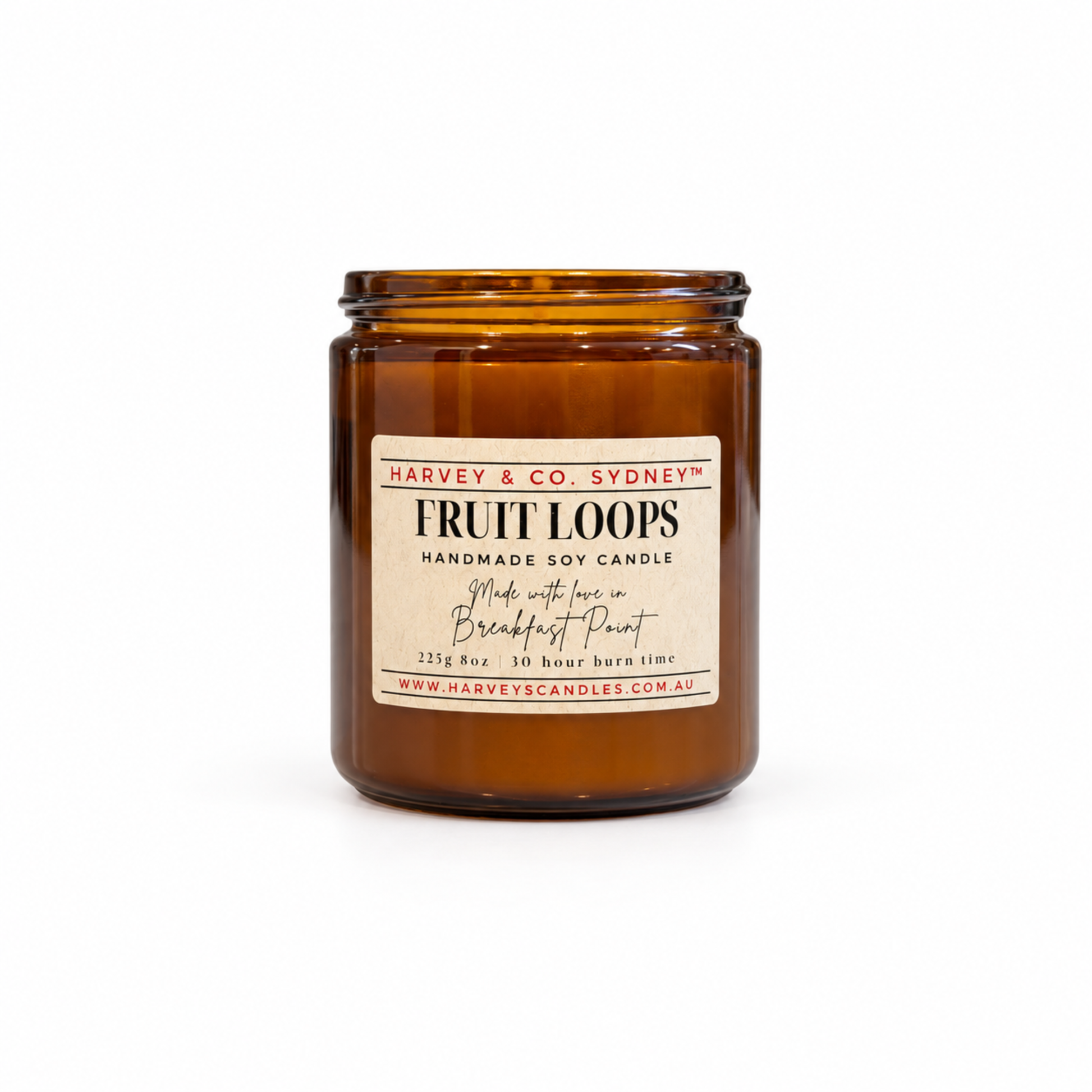 An amber glass jar candle with a cream-colored label reading 'Harvey & Co. Sydney Fruit Loops Handmade Soy Candle' on a clean white background.