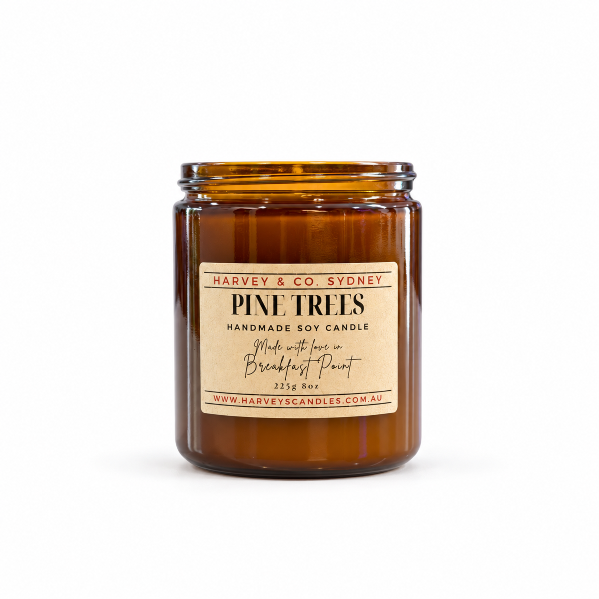 An amber glass jar candle with a cream-colored paper label reading 'PINE TREES' by Harvey & Co Sydney, photographed on a clean white background.