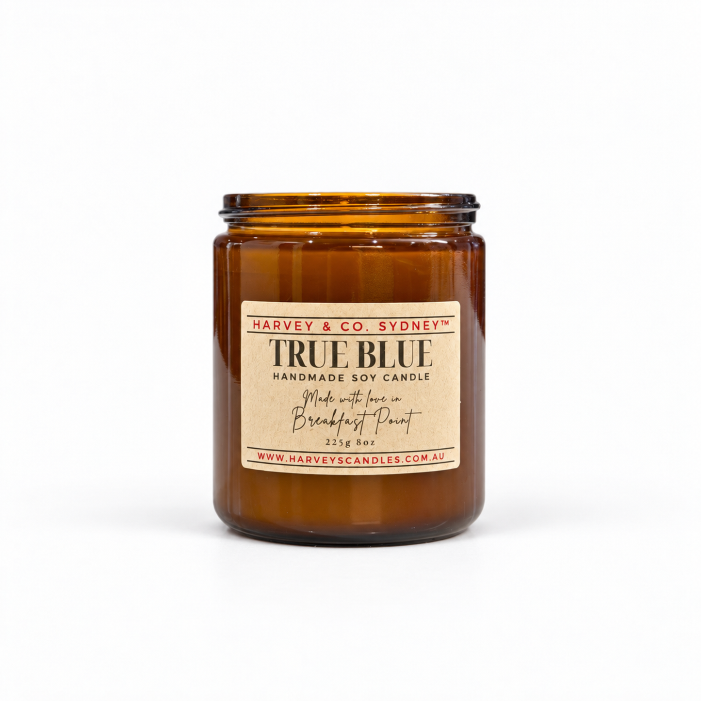 An amber glass jar candle with a beige paper label reading 'TRUE BLUE HANDMADE SOY CANDLE' and 'Harvey & Co. Sydney' at the top, photographed on a clean white background.