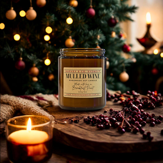 Jar of mulled wine candle with a Christmas tree in the background