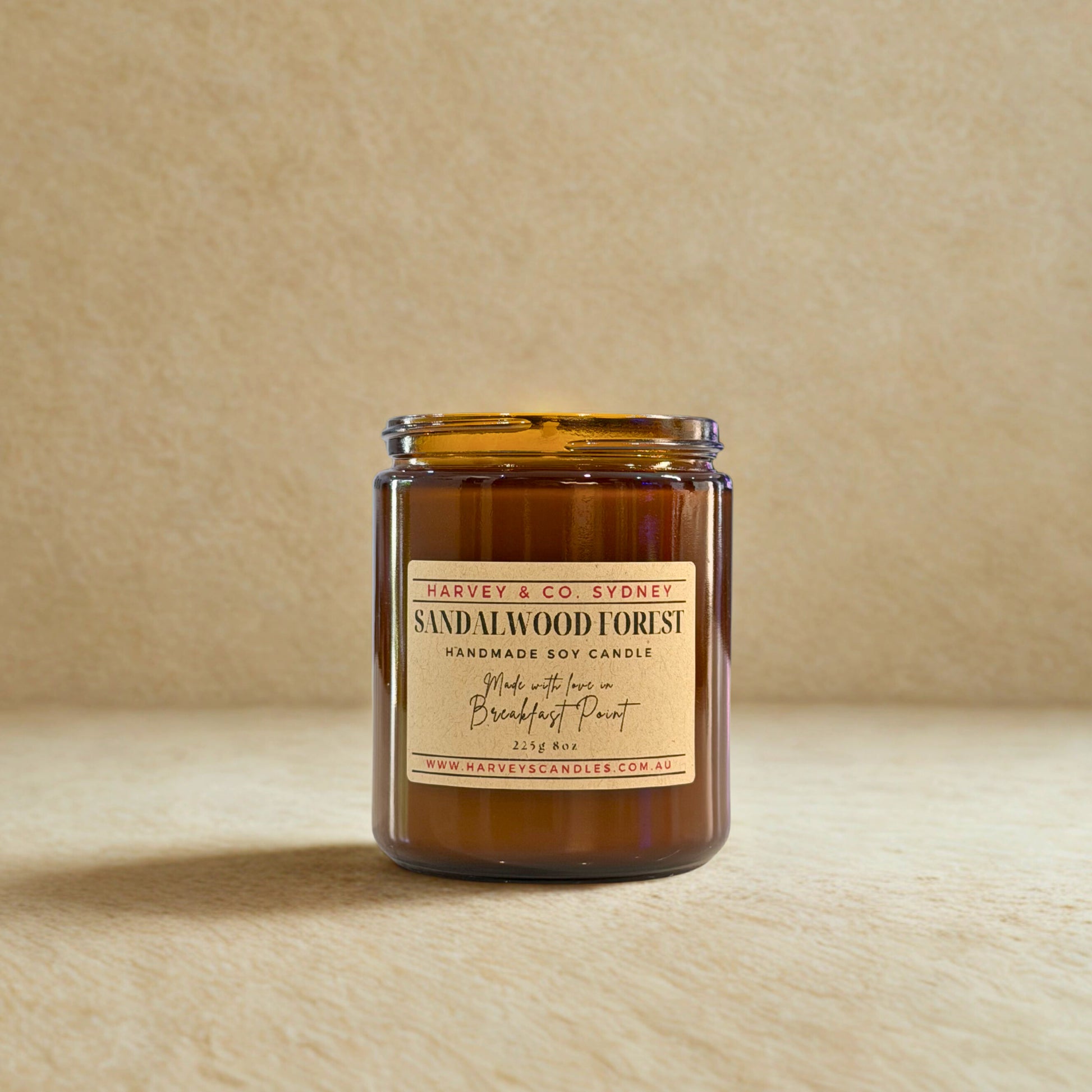 Sandalwood forest candle in amber jar with label on a beige background