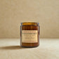 Sandalwood forest candle in amber jar with label on a beige background