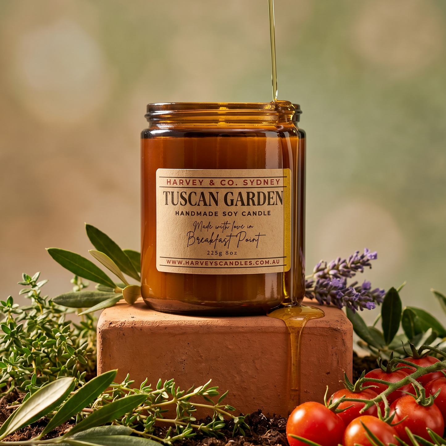 Jar of Tuscan Garden candle with honey being drizzled over it, surrounded by herbs and tomatoes.