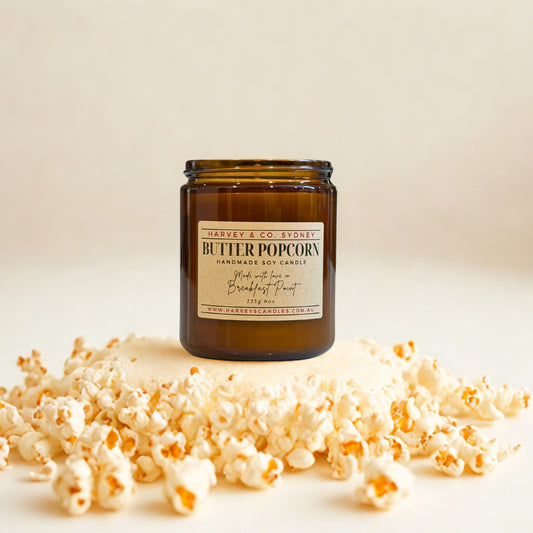 Butter popcorn soy jar candle in amber glass with hand-poured wax, shown with the label facing forward