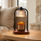 Candle in a glass jar with a wooden base on a table in a cozy living room.