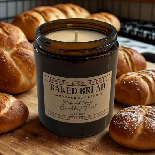 Baked Bread candle by Harvey & Co. Sydney surrounded by bread loaves on a wooden surface.