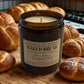 Baked Bread candle by Harvey & Co. Sydney surrounded by bread loaves on a wooden surface.