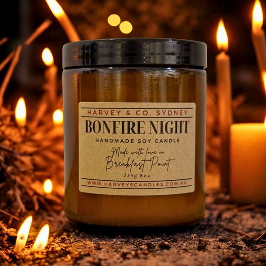Harvey & Co. Sydney 'Bonfire Night' candle with a warm glow and blurred candles in the background.