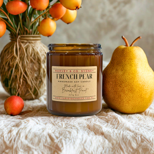 Harvey & Co. Sydney French Pear candle with a pear and oranges on a textured surface