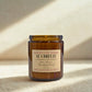 Brown candle jar with a label on a beige background