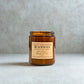 Brown candle jar with a label on a light gray background