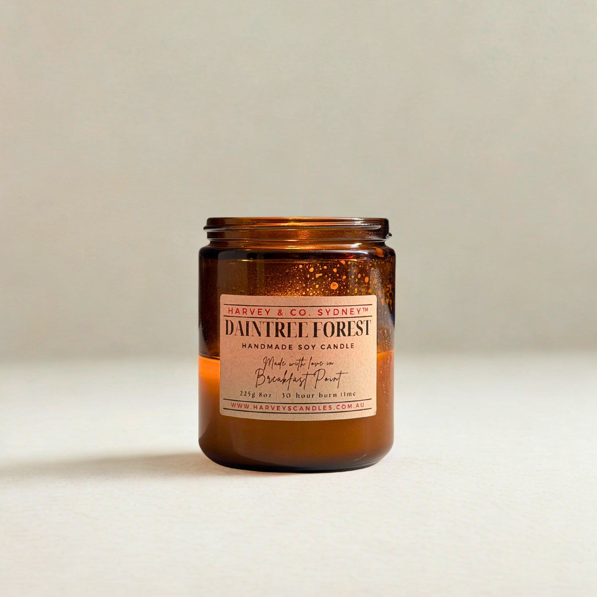 Amber glass candle with a label on a light background