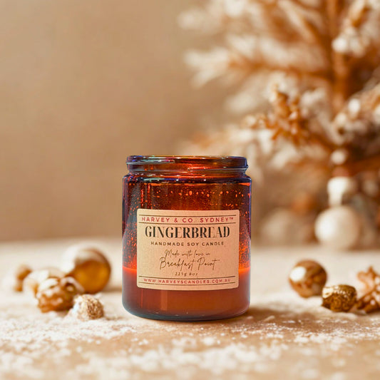 Gingerbread scented candle in an amber jar with decorative elements on a neutral background