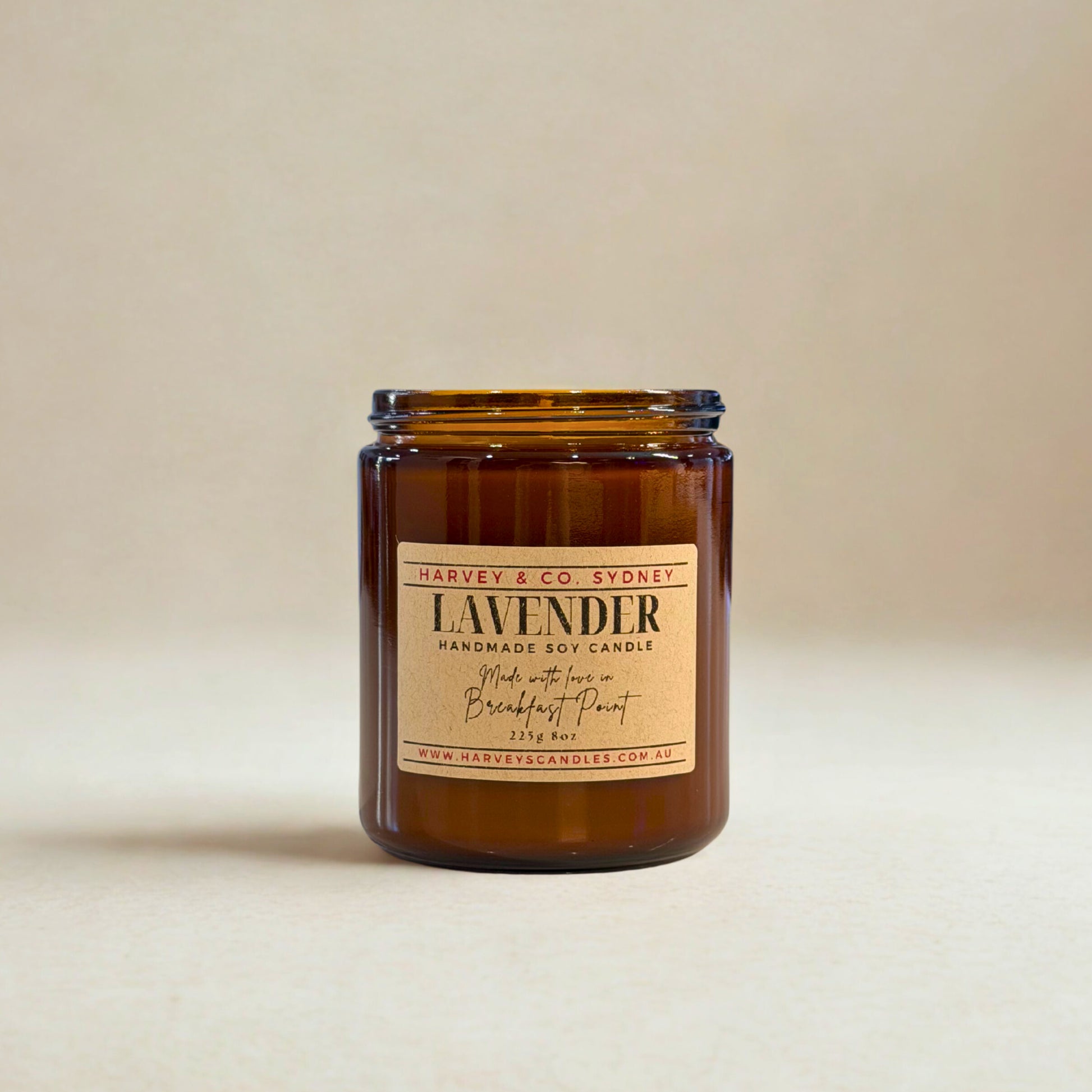 Amber glass candle with a label on a beige background