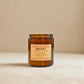 Brown candle with a label on a beige background