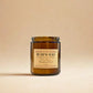 Brown candle jar with a label on a beige background