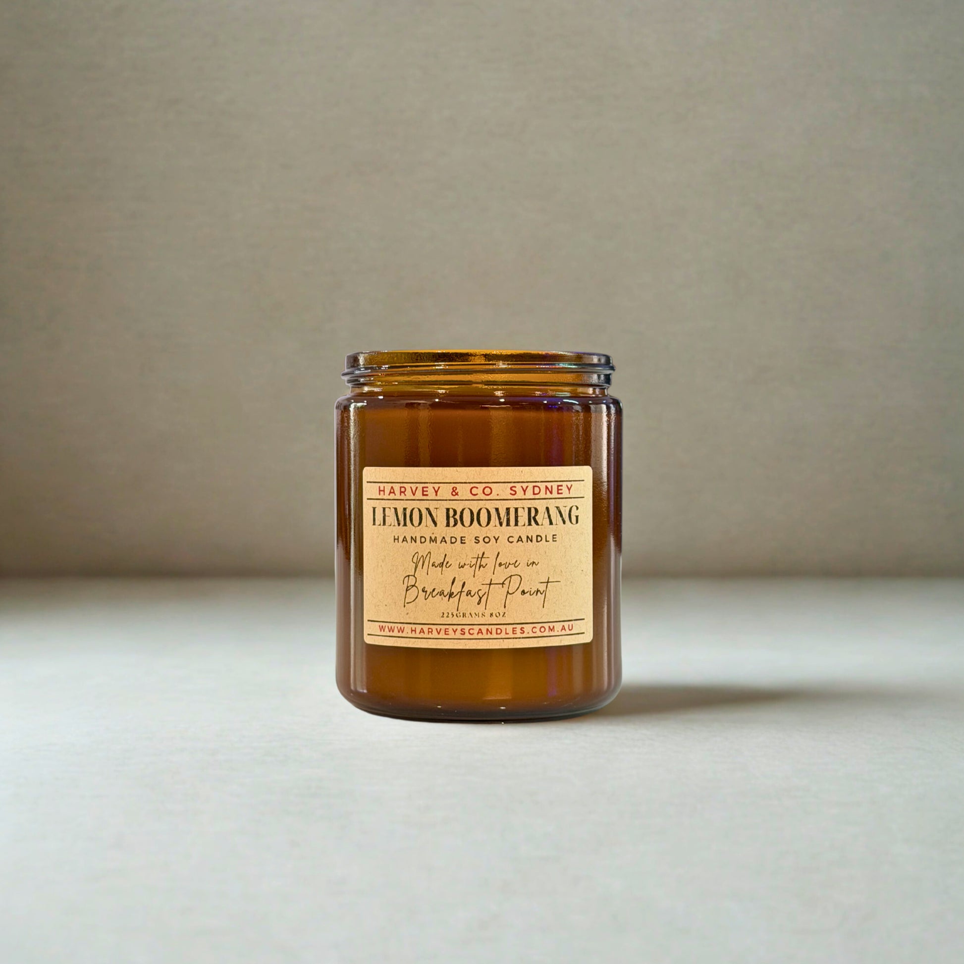 Amber candle jar with a label on a neutral background