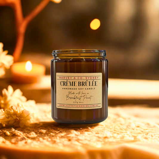 Harvey & Co. Sydney Crème Brèlé candle on a wooden surface with blurred background