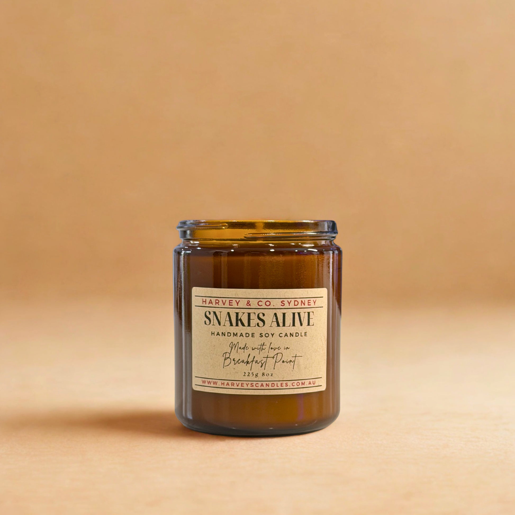 Candle in a glass jar with a label on a beige background