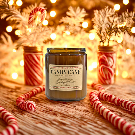 Candle labeled 'Candy Cane' with candy canes and festive lights in the background