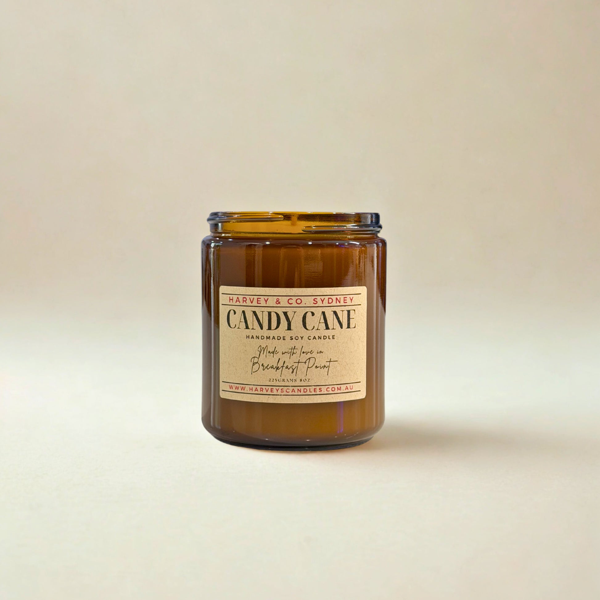 Brown candle jar with a label on a beige background