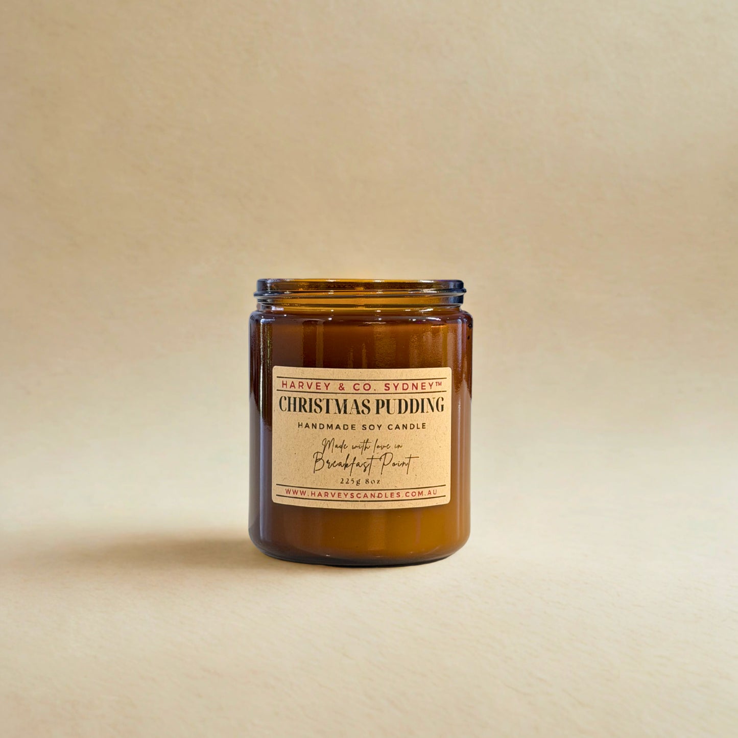 Brown candle jar with a label on a beige background