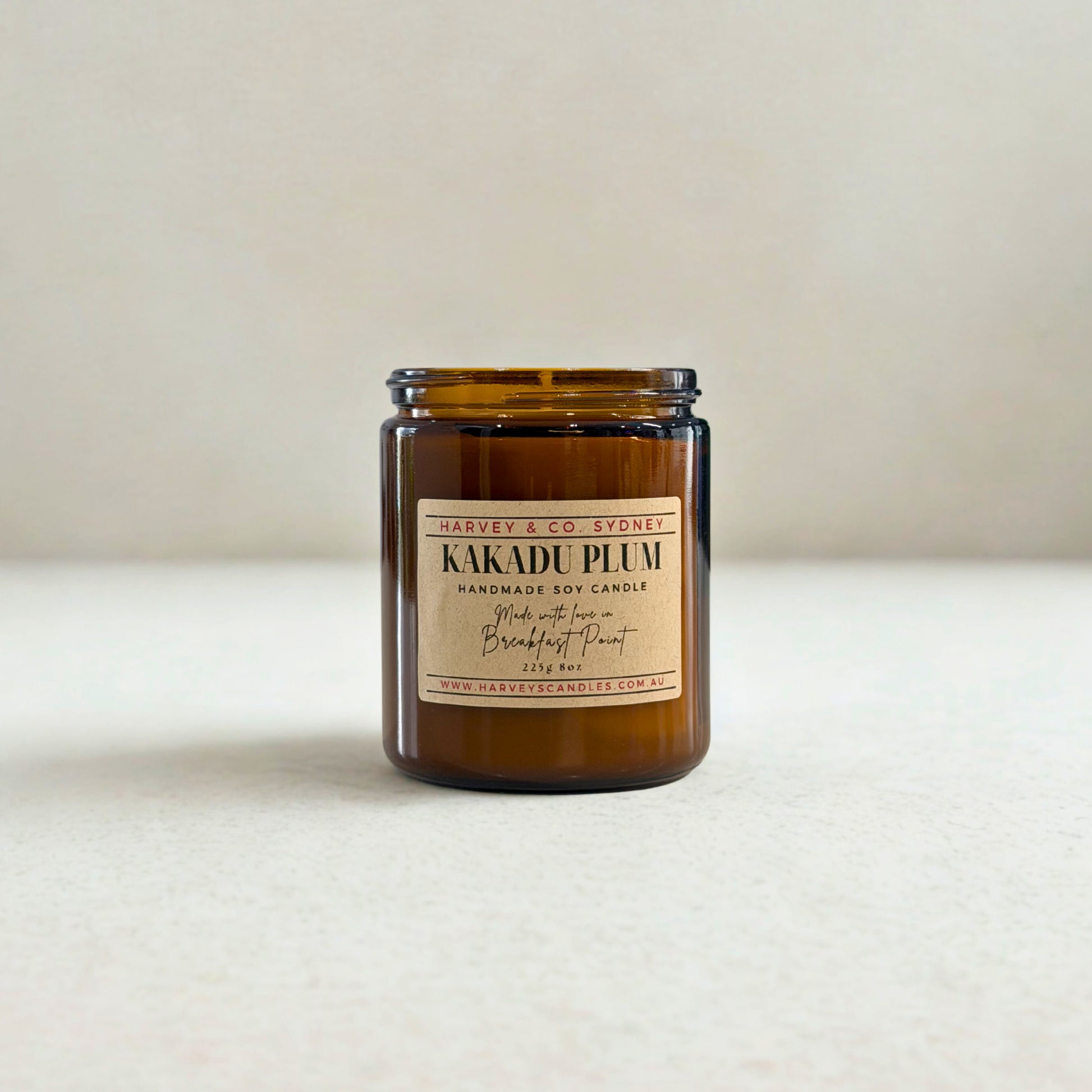 Brown candle jar with a label on a white surface