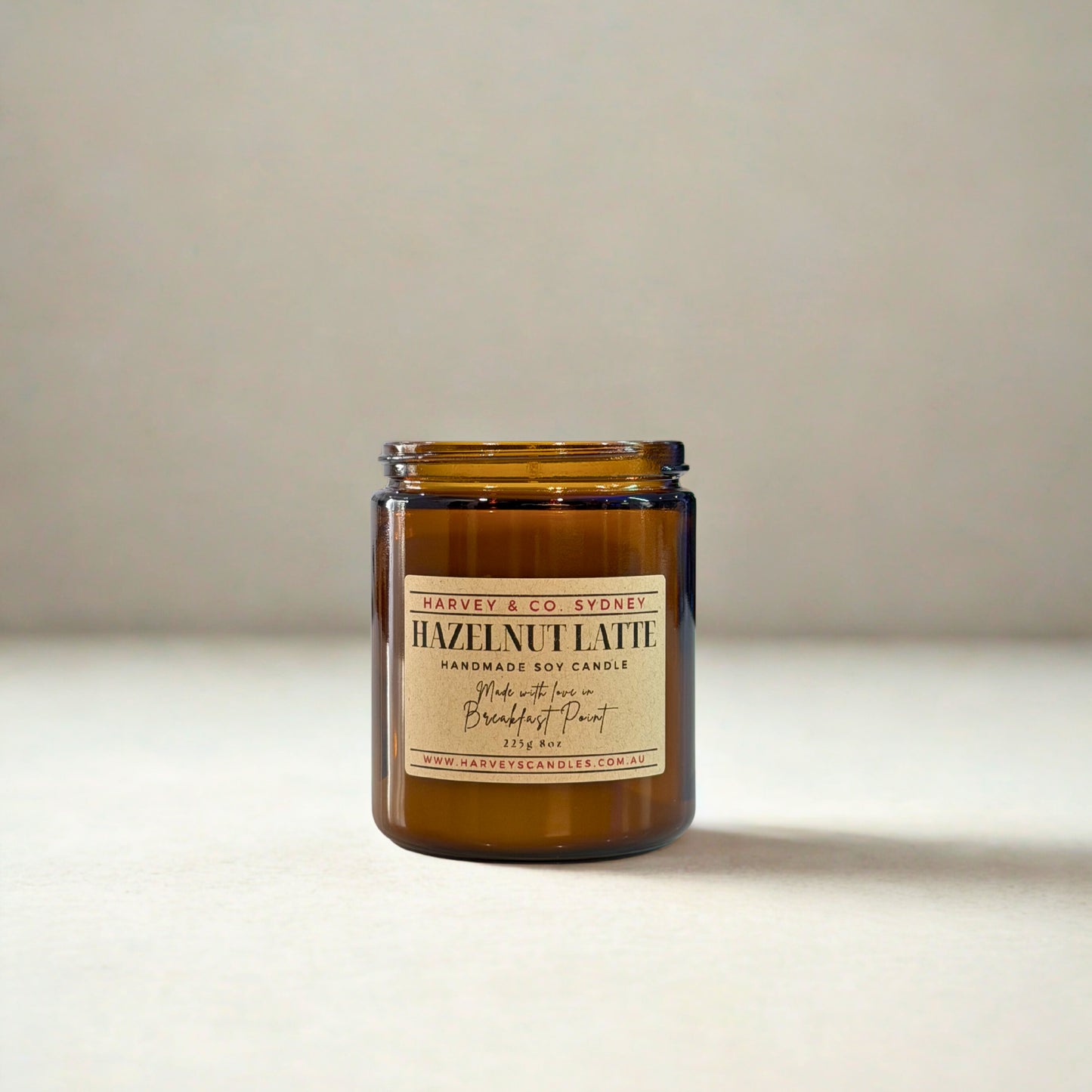 Amber glass candle with a label on a neutral background