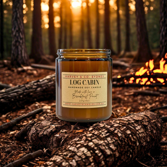 Harvey & Co. Sydney Log Cabin candle on a log with a forest background