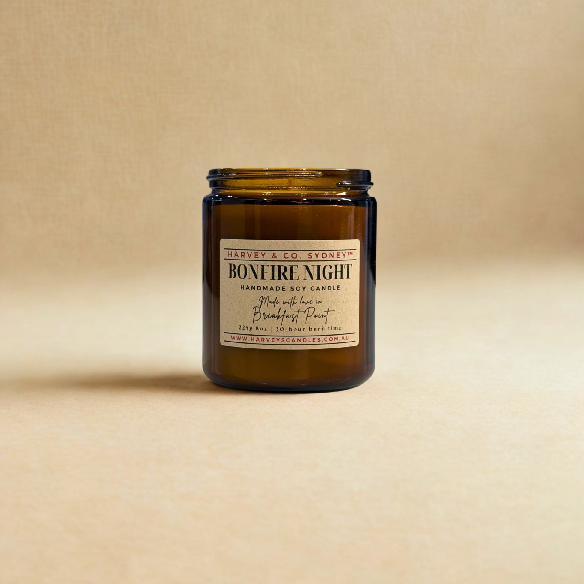 Candle in a amber jar with a label on a beige background