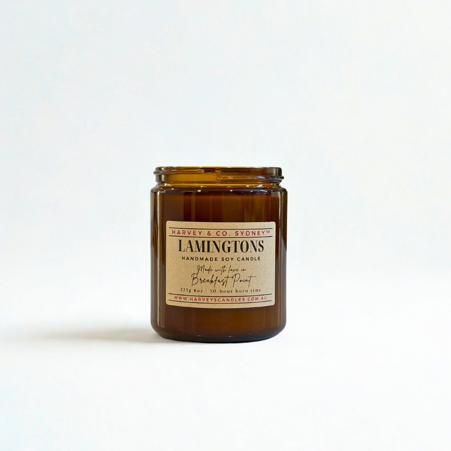 Amber glass candle jar with a label on a white background
