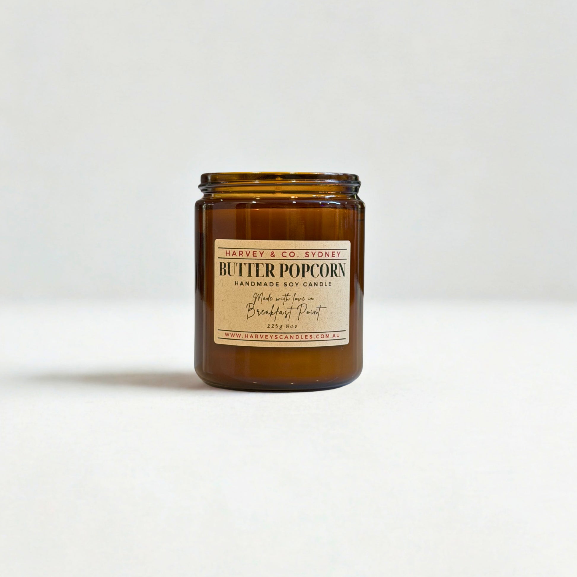 Amber glass candle with a label on a white background