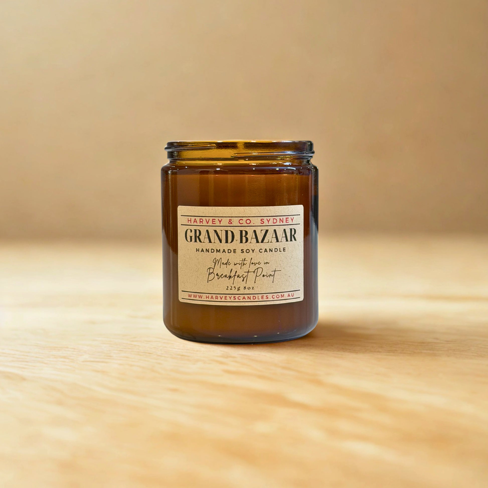 Candle jar labeled 'Grand Bazaar' by Harvey & Co. Sydney on a wooden surface with a beige background