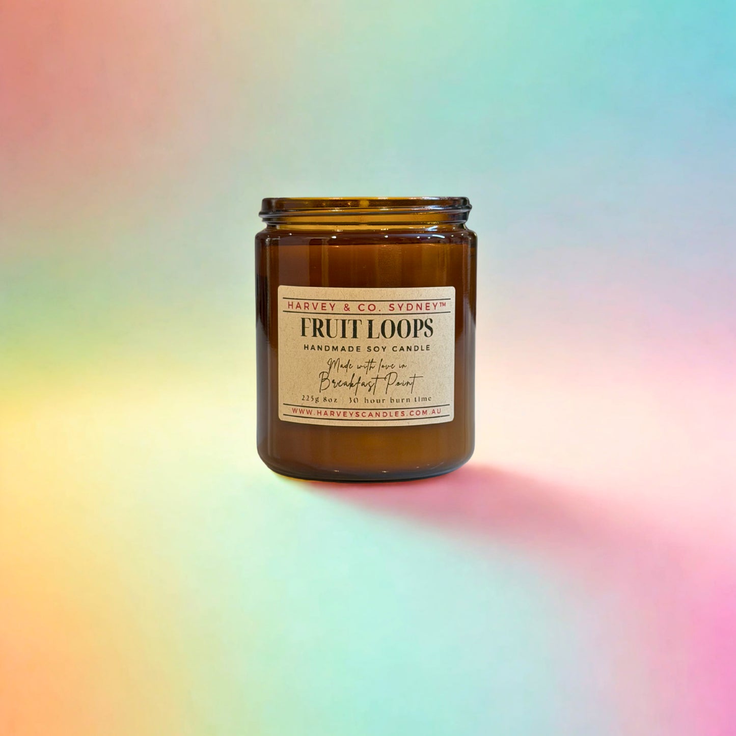 Brown candle jar labeled 'Fruit Loops' on a colorful gradient background