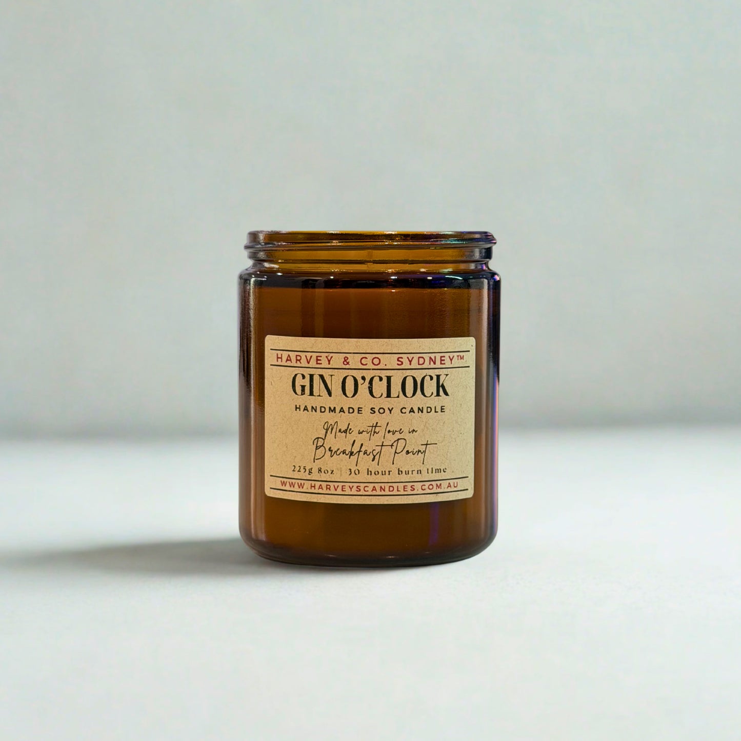 Amber glass candle with a label on a light gray background