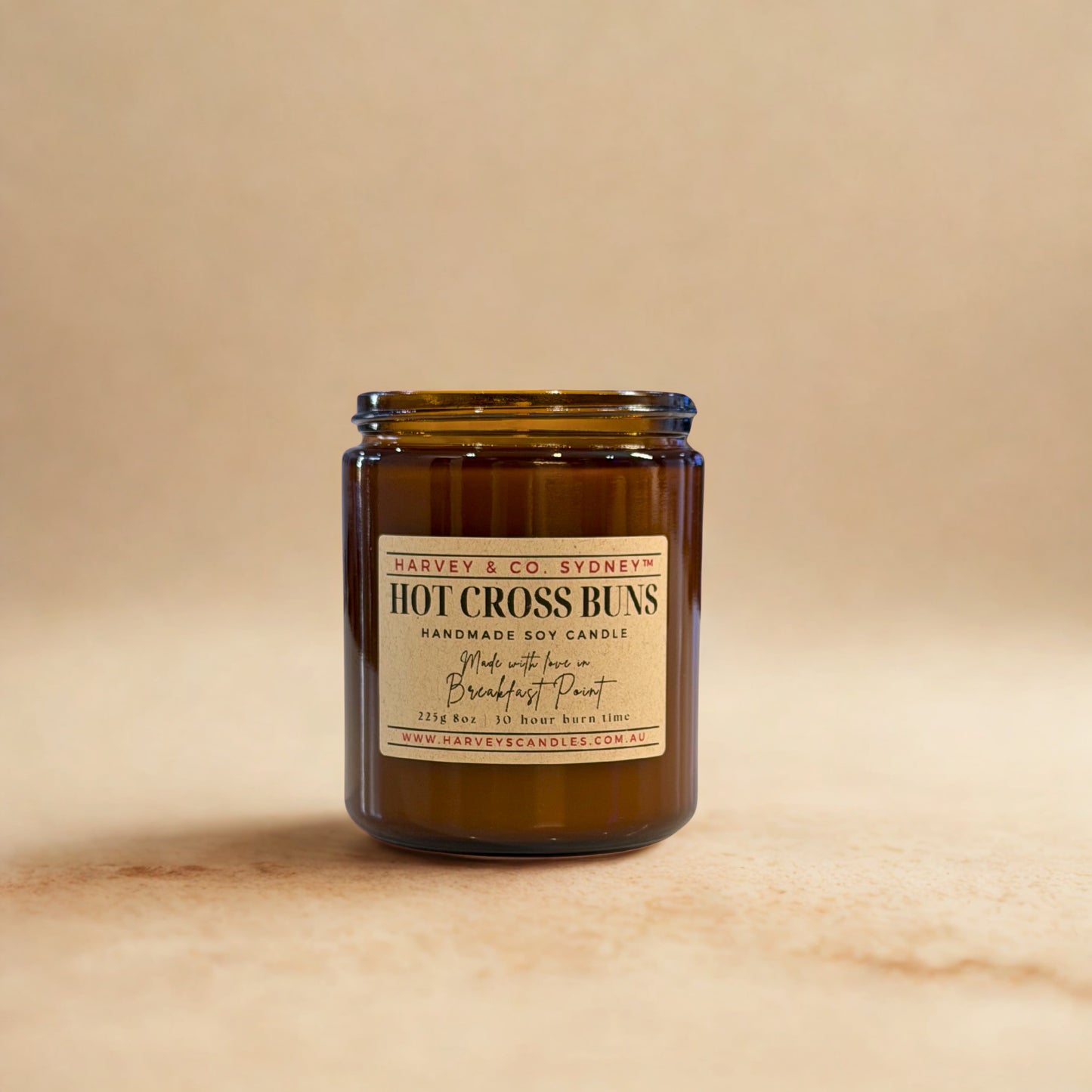 Brown candle jar with a label on a beige background