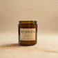 Brown candle jar with a label on a beige background