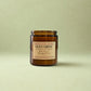Brown candle jar with a label on a light green background