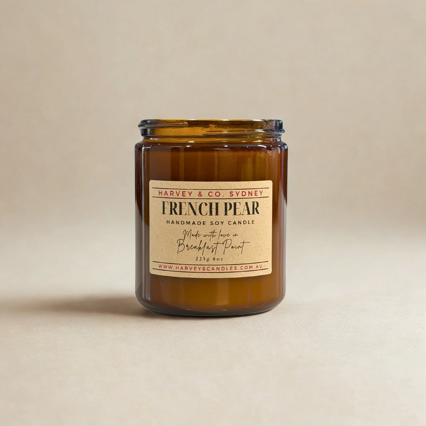 Brown candle in a glass jar with a label on a beige background