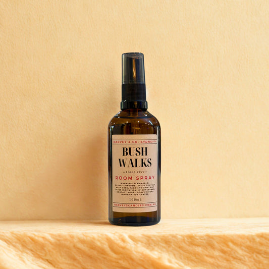 Bottle of Bush Walks room spray on a wooden surface with a beige background
