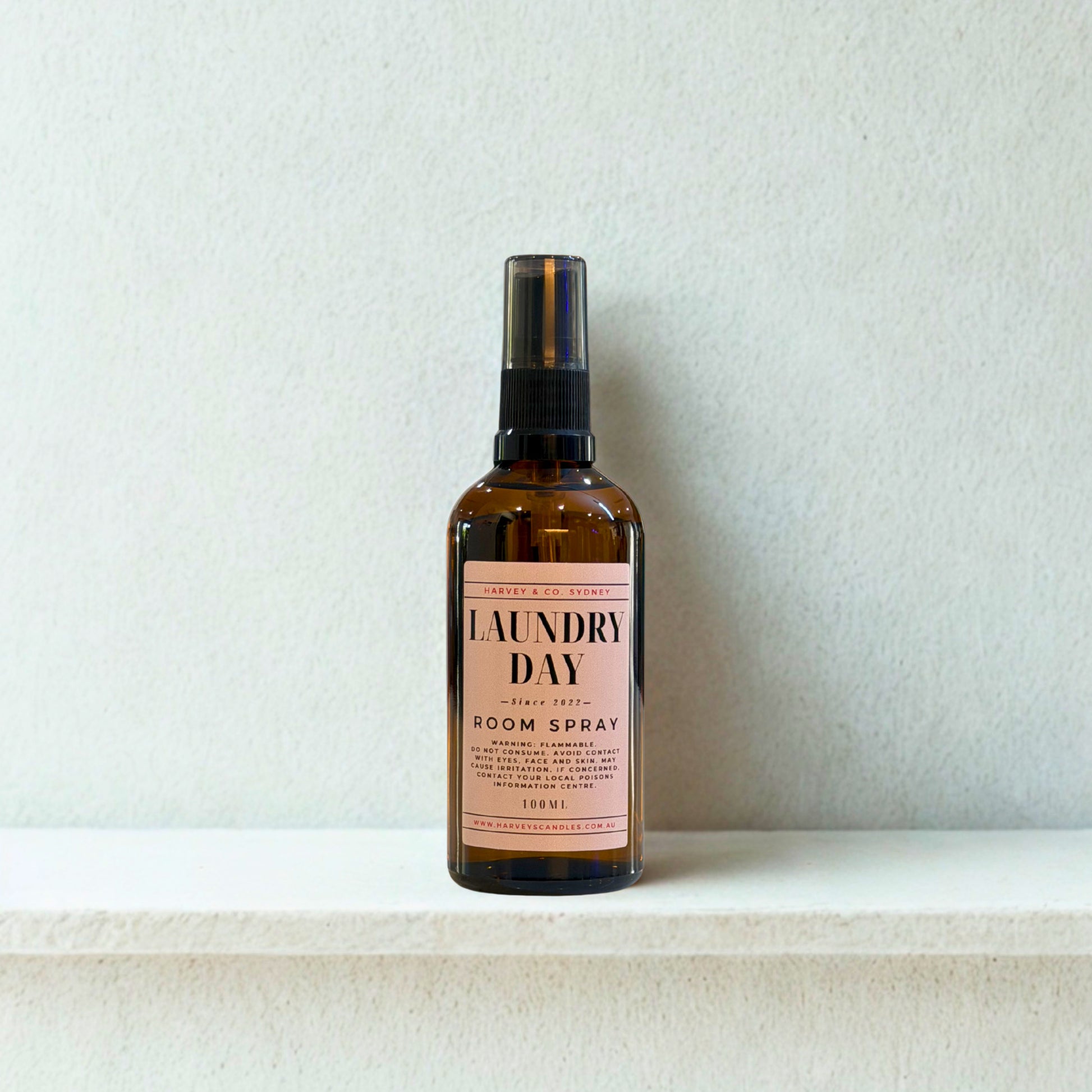 Bottle of 'Laundry Day' room spray on a white surface with a light gray background