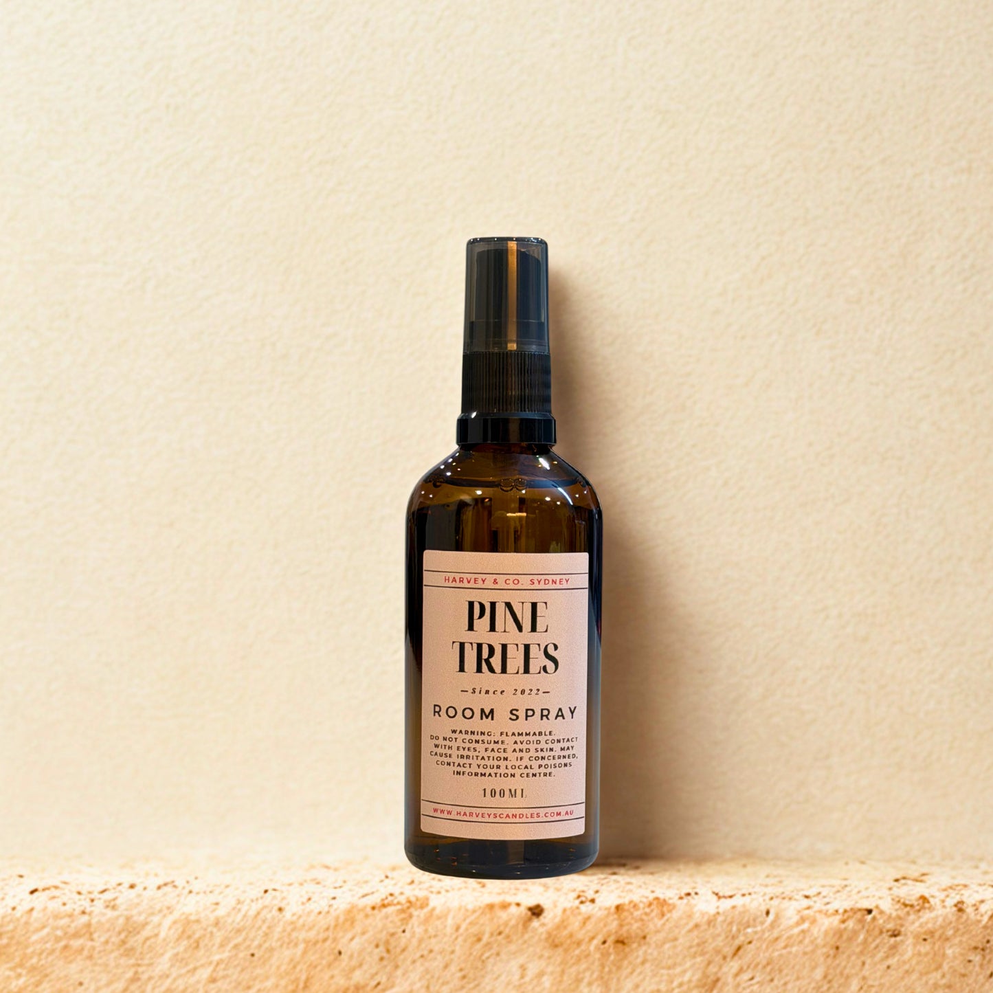 Bottle of Pine Trees room spray on a beige surface with a beige background