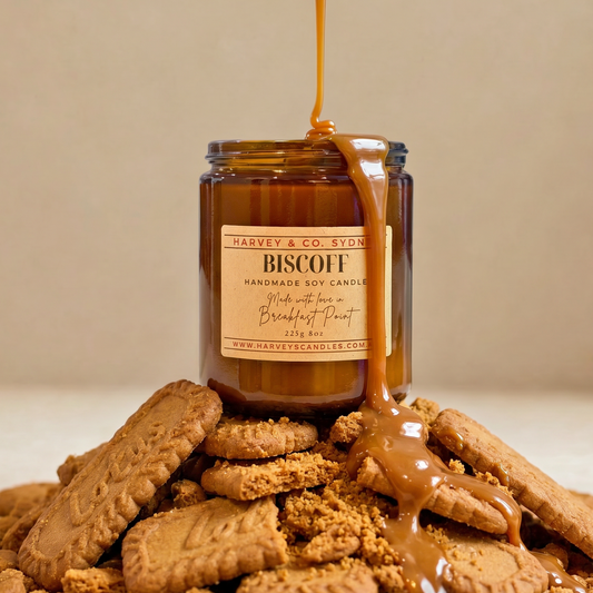 Jar of 'Biscuit' candle with caramel drizzle over cookies on a beige background