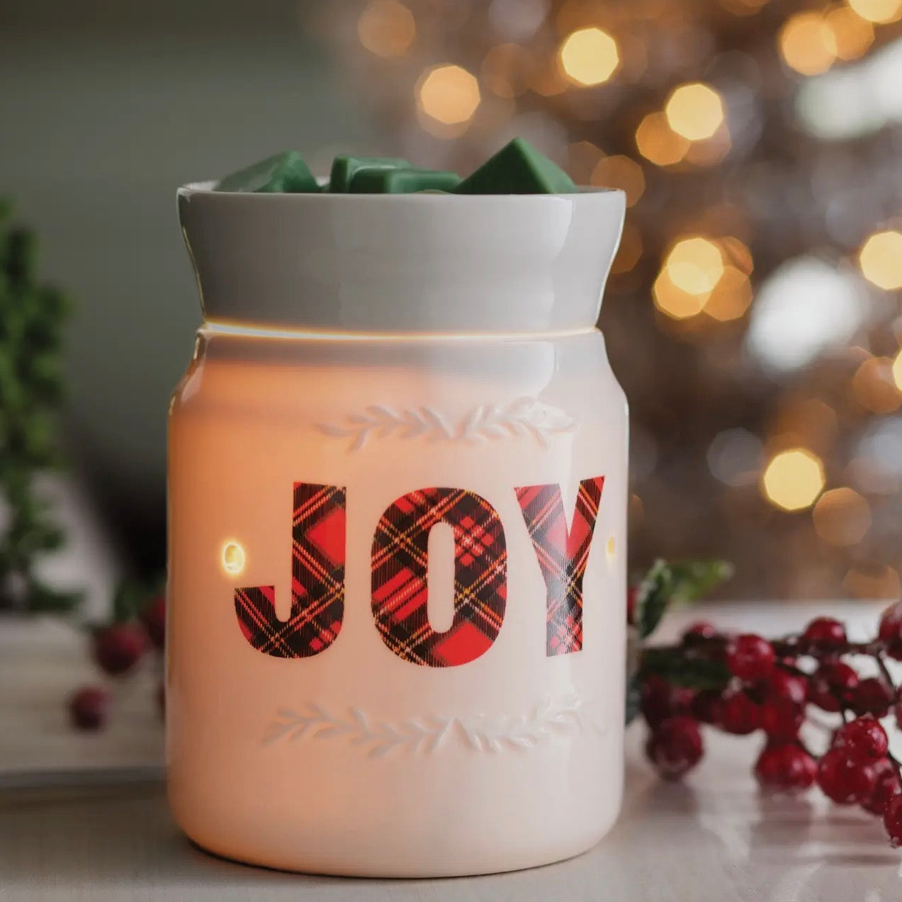 Decorative lantern with 'JOY' in plaid pattern against a festive background
