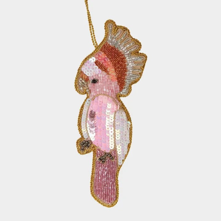 Decorative seahorse ornament with pink and gold details on a white background