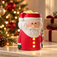 Santa Christmas wax melter with a red coat and glowing buttons, displayed beside wrapped gifts and a softly lit Christmas tree.