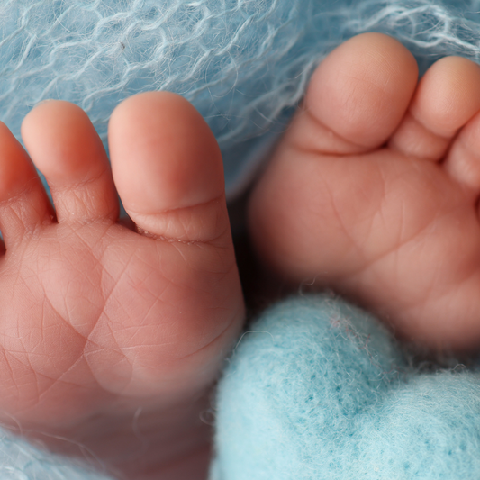 Close-up of a baby's feet wrapped in blue fabric