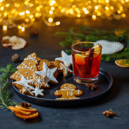Spiced rum soy candle in a jar container with amber glass, shown with gingerbread and festive bokeh lights.